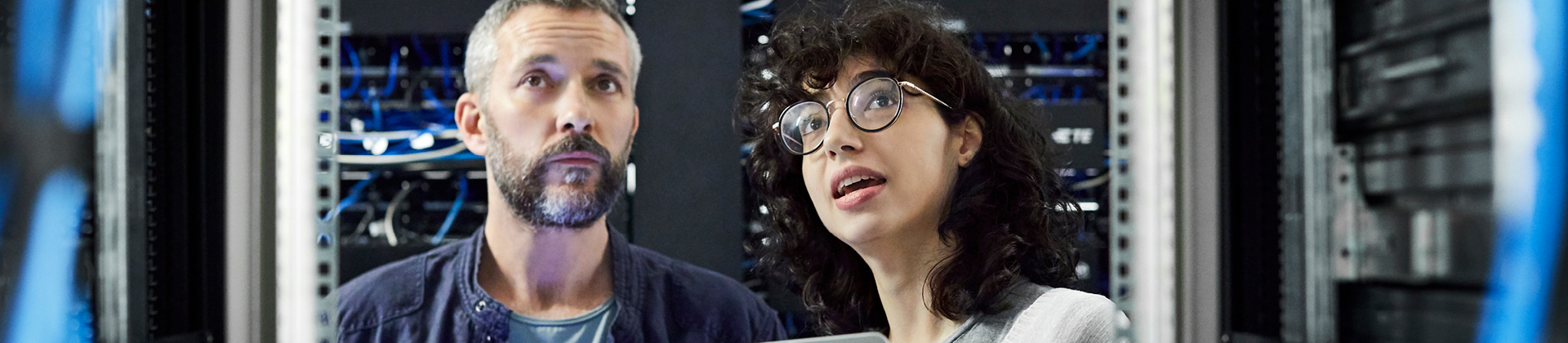 man and woman in server room looking up in awe 