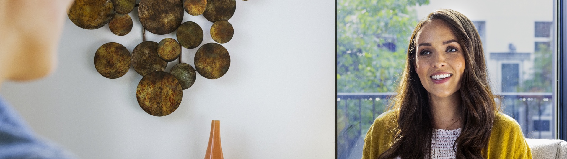 woman sitting in office smiling at man across from her