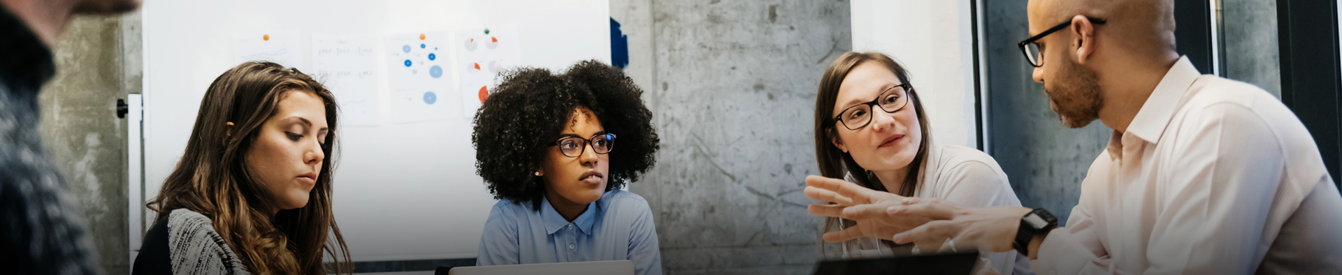 people sit across a table in a meeting